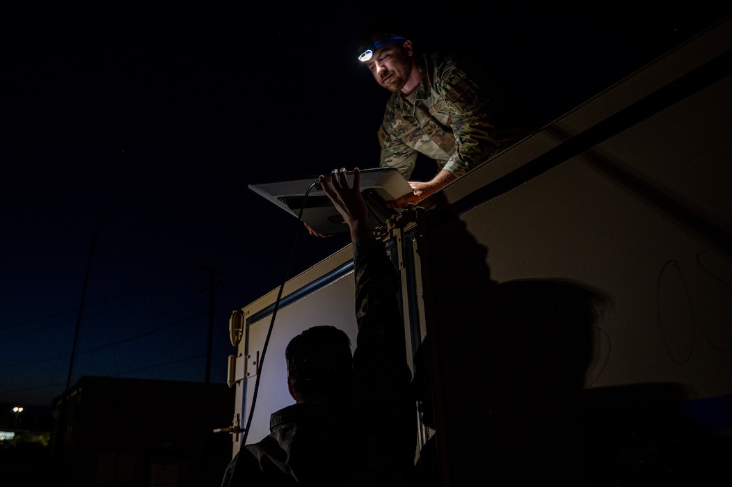 U.S. Air Force Staff Sgt. Nathan Knight, 23rd Communications Squadron infrastructure supervisor, hands a Starlink antenna to an Airmen during Exercise Ready Tiger 24-1 at Savannah Air National Guard Base, Georgia, April 14, 2024. Ready Tiger 24-1 is a readiness exercise demonstrating the 23rd Wing’s ability to plan, prepare and execute operations and maintenance to project air power in contested and dispersed locations, defending the United States’ interests and allies. (U.S. Air Force photo by Senior Airman Courtney Sebastianelli)