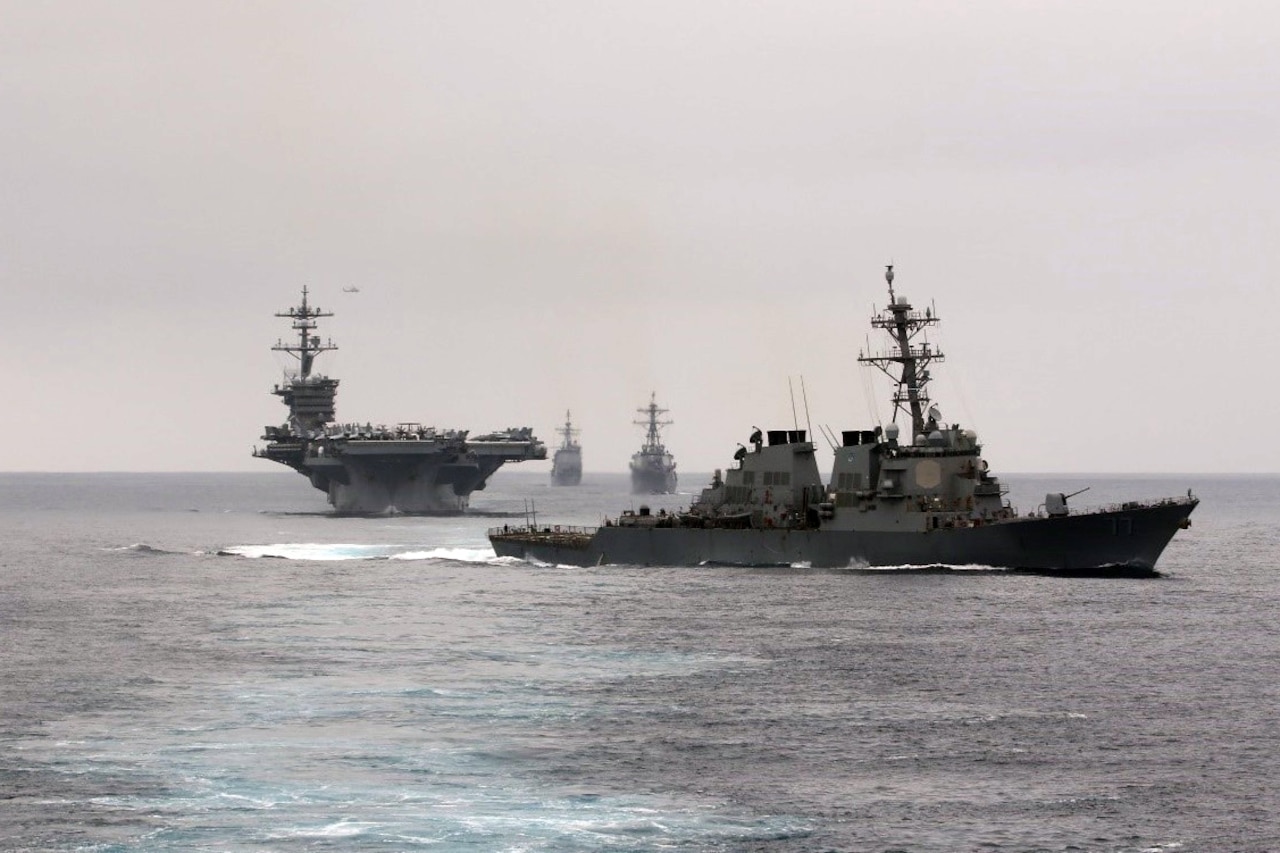 Several large, military ships operate near each other.