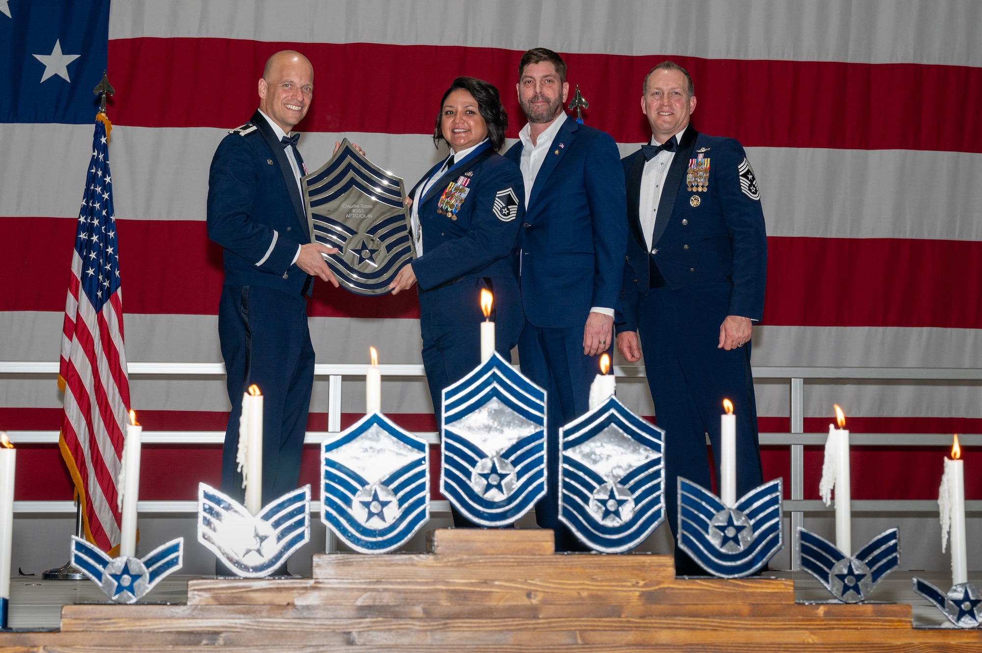 U.S. Air Force Senior Master Sgt. Claudia Tobin, the Air Force Test Center plans and resources flight chief, receives a recognition plaque during the chief master sergeant recognition ceremony at Nellis Air Force Base, Nevada, April 20, 2024.