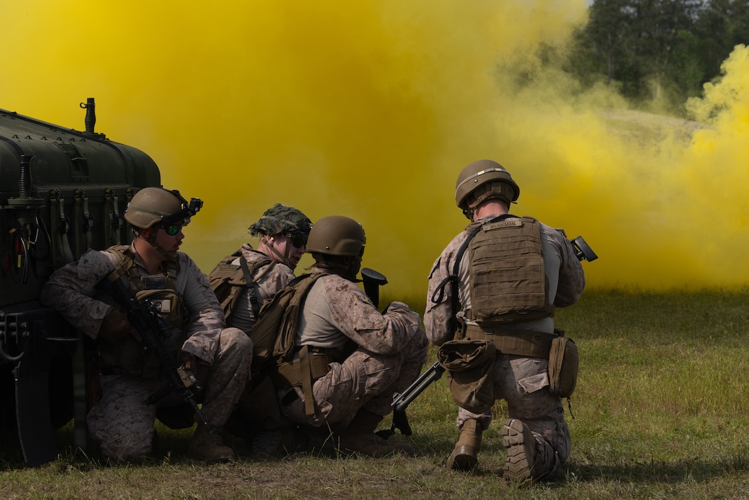 U.S. Marines with Alpha Battery, 2nd Low Altitude Air Defense (LAAD) Battalion, throw smoke grenades during a counter-unmanned aircraft system (UAS) range on Marine Corps Base Camp Lejeune, North Carolina, April 16, 2024. 2nd LAAD Battalion conducted a dynamic, tactical scenario-driven counter-UAS aerial-gunnery range in which Marines had to shoot, maneuver, and communicate while directly engaging UAS aircraft. (U.S. Marine Corps photo by Lance Cpl. Anakin Smith)