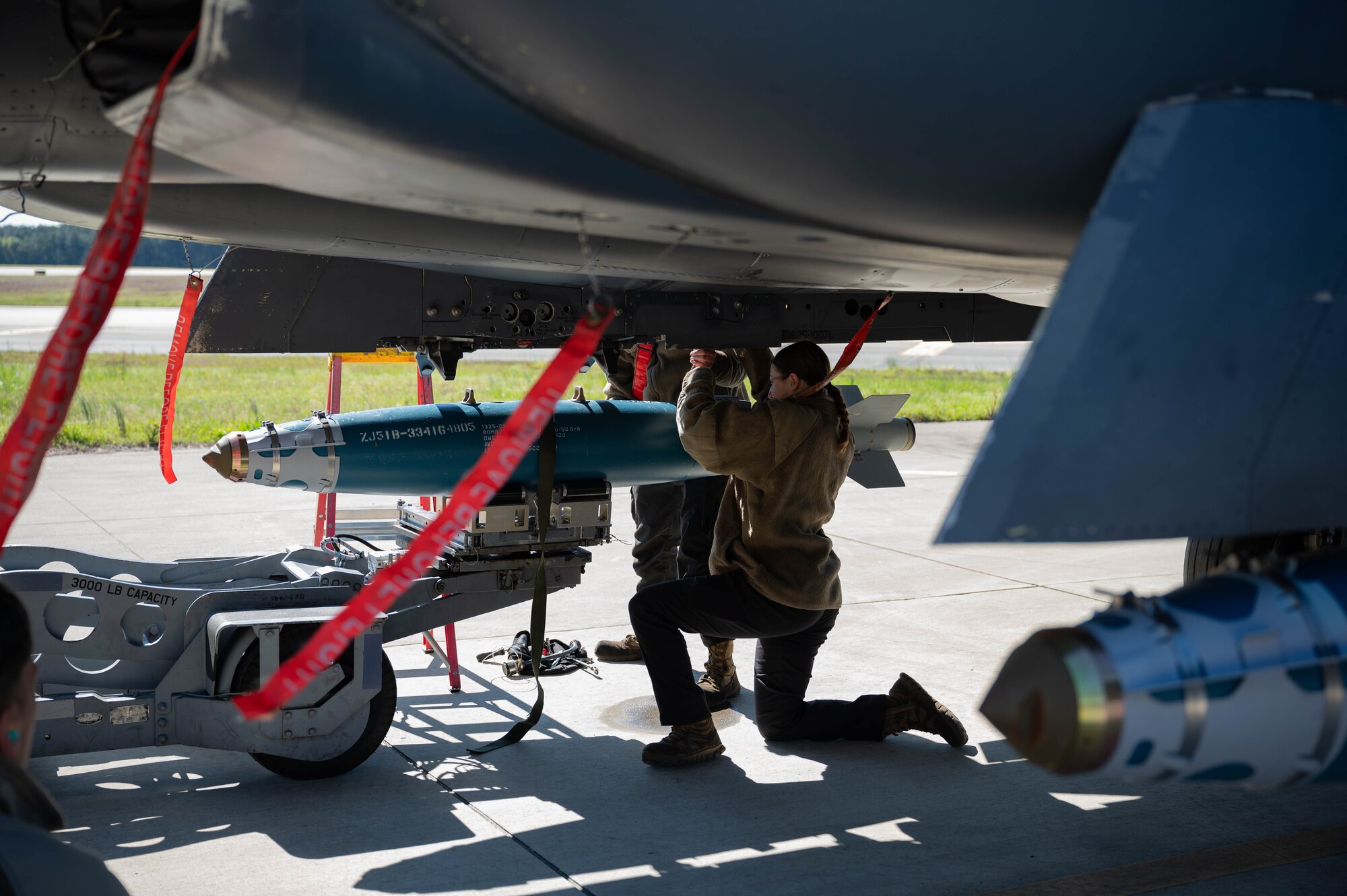 U.S. Air Force Staff Sgt. Christina Olazagsti, a weapons load crew member assigned to the 333rd Fighter Generation Squadron load crew team, stabilizes a weapon onto an F-15E Strike Eagle during a quarterly load crew competition at Seymour Johnson Air Force Base, North Carolina, April 5, 2024. Load crew competitions are a friendly competition between the 4th Fighter Wing’s fighter generation squadrons. (U.S. Air Force photo by Airman 1st Class Rebecca Sirimarco-Lang)