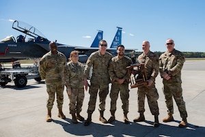 U.S. Air Force Airmen assigned to the 334th Fighter Squadron pose with the trophy during a quarterly load crew competition at Seymour Johnson Air Force Base, North Carolina, April 5, 2024. Load crew competitions are a friendly competition between the 4th Fighter Wing’s fighter generation squadrons. (U.S. Air Force photo by Airman 1st Class Rebecca Sirimarco-Lang)