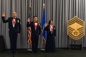 U.S. Air Force Senior Master Sgts. Christian Ruiz, left, 436th Aerial Port Squadron air freight superintendent, Kyle Nason, center, 436th Civil Engineer Squadron Explosive Ordnance Disposal flight superintendent and U.S. Air Force Reserve Chief Master Sgt. Kelly Sobieski, right, 71st Aerial Port Squadron port manager, raise their right hand and recite the chief’s charge during the 2024 Chief Recognition Ceremony at Dover Air Force Base, Delaware, April 19, 2024. The ceremony was held to recognize those who have achieved the highest enlisted rank that, by law, can only be held by one percent of all enlisted members. (U.S. Air Force photo by Roland Balik)