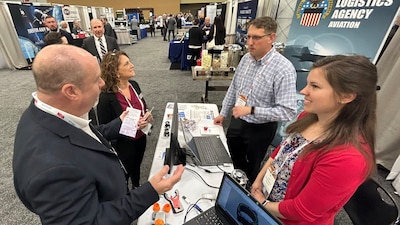 DLA Aviation employees talk to attendees at conference