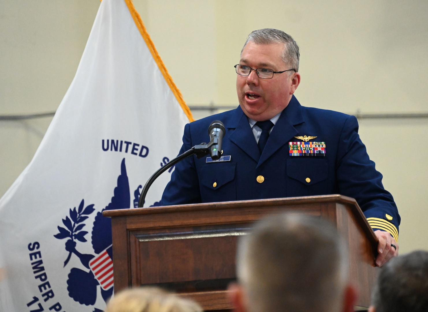 U.S. Coast Guard Timothy Williams, commander of Air Station Kodiak, presides over an Air Station Kodiak ceremony to retire the MH-65 Dolphin helicopter airframe April 23, 2024. Air Station Kodiak will be the fourth Coast Guard Air Station to transition to a single rotary-wing ship and shore-based fleet of nine MH-60 Jayhawks in 2025. (U.S. Coast Guard photo by Petty Officer Second Class Ian Gray)