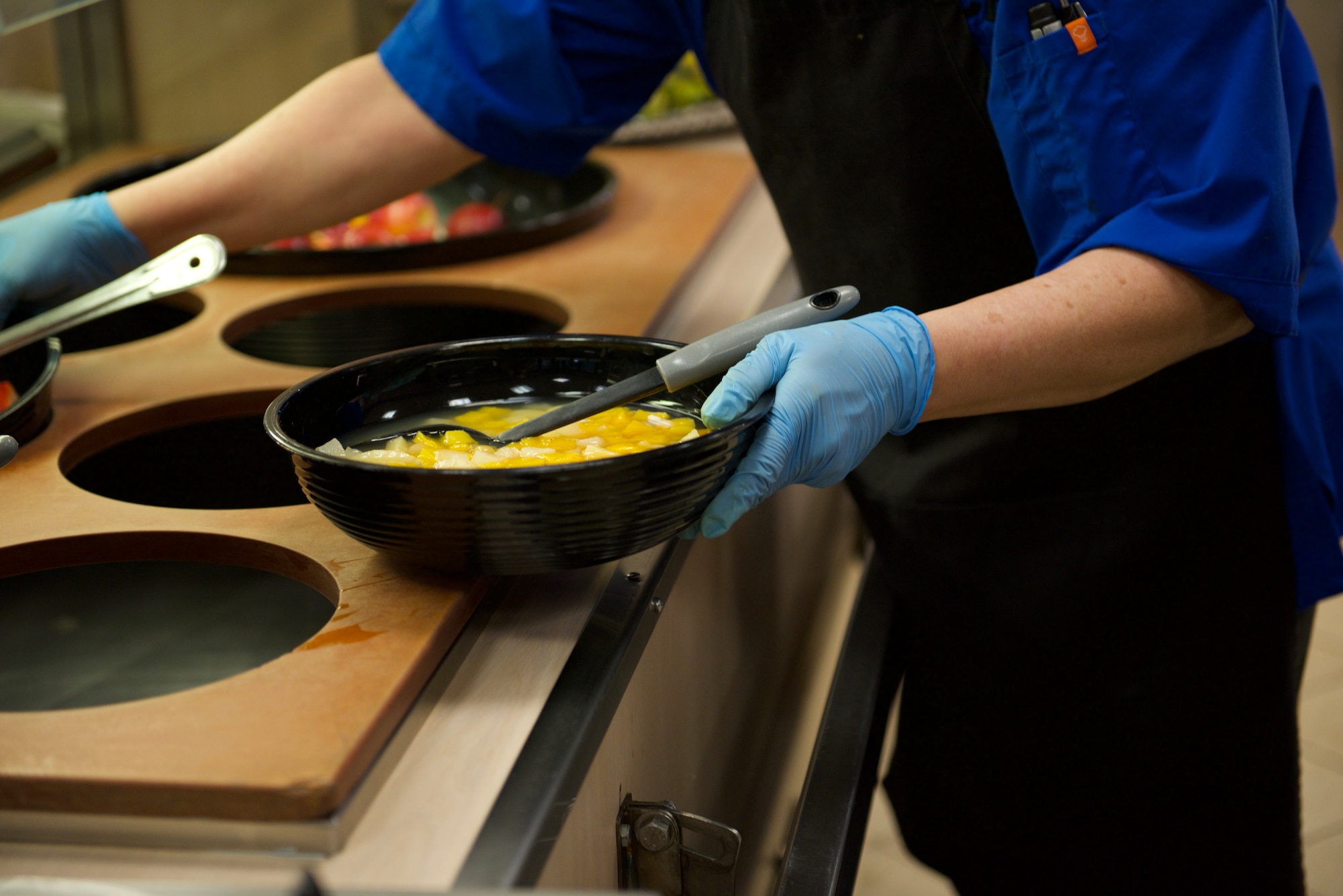 U.S. Air Staff Sgt. Force Charles Camantigue, a cook with the 627th Force Support Squadron Olympic Dining Facility, restocks fruit in the dining facility at Joint Base Lewis-McChord, Washington, Feb. 13, 2024. The Olympic Dining Facility supports all Team McChord service members, families, and retired service members with meals three times a day, every day. (U.S. Air Force photo by Airman 1st Class Megan Geiger)