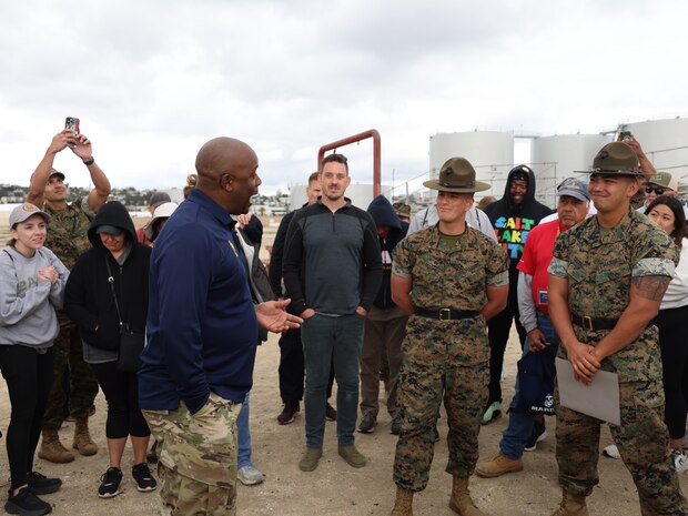 A retired U.S. Army Sgt. Maj., Sgt. Maj. Norbert Portis, awards Staff Sgt. Gustavo FelixGomez and Staff Sgt. Colebradle Castro with unit coins during the Marine Corps Educators Workshop in San Diego, Calif., on April 4, 2024. The Educators Workshop is a four-day program designed to better inform high school educators and influencers about the benefits and opportunities available during service in the Marine corps. (U.S. Marines Corps photo by Sgt. Menelik Collins)