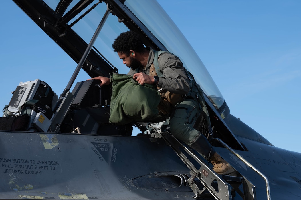An Airman gets into the cockpit of an F-16 for a flight.