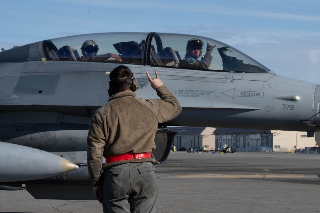 An Airman gives the signal to begin taxiing.