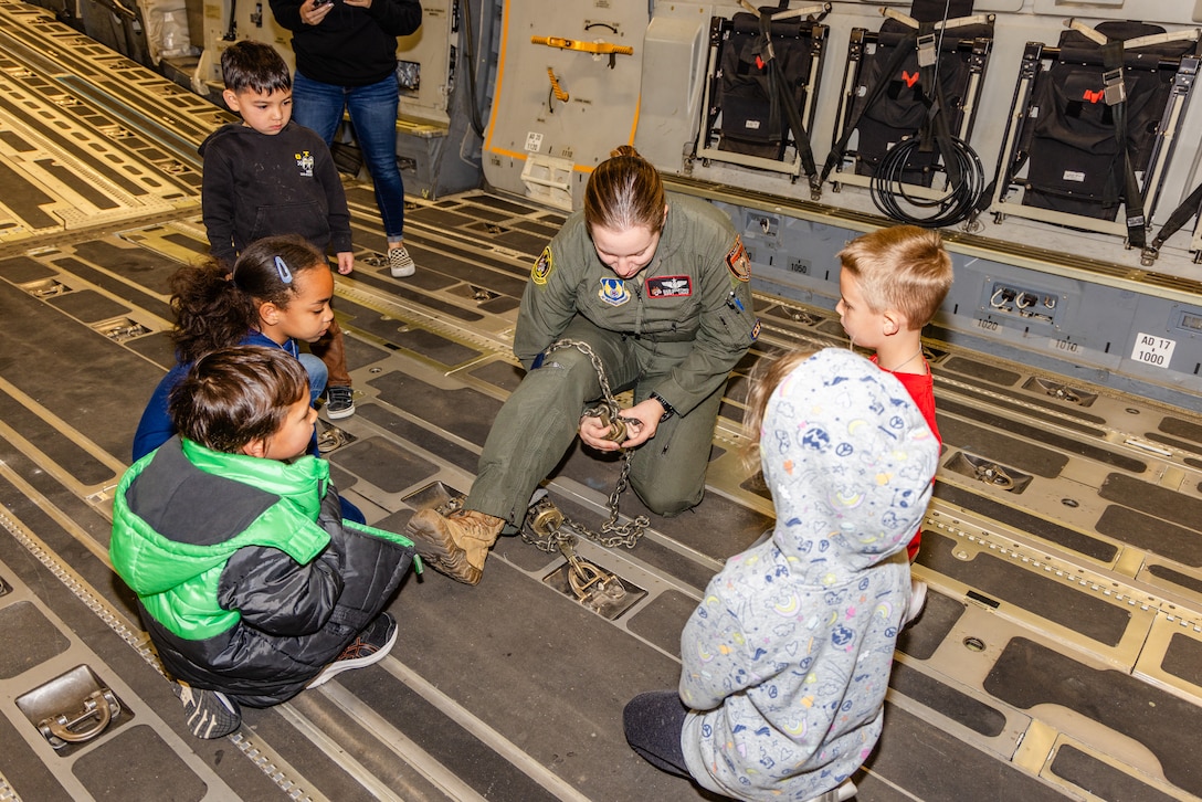 Edwards children receive a brief on C-17 Globemaster III operations from Tech. Sgt. Samantha Martino, 418th Flight Test Squadron, while onboard the aircraft during Operation Kids Understand Deployment Operations or KUDOS at Edwards Air Force Base, California, March 1. (Air Force photo by Lindsey Iniguez)