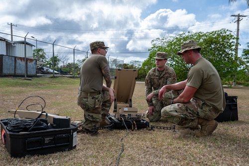 Airmen raise a small standard shelter during an exercise.