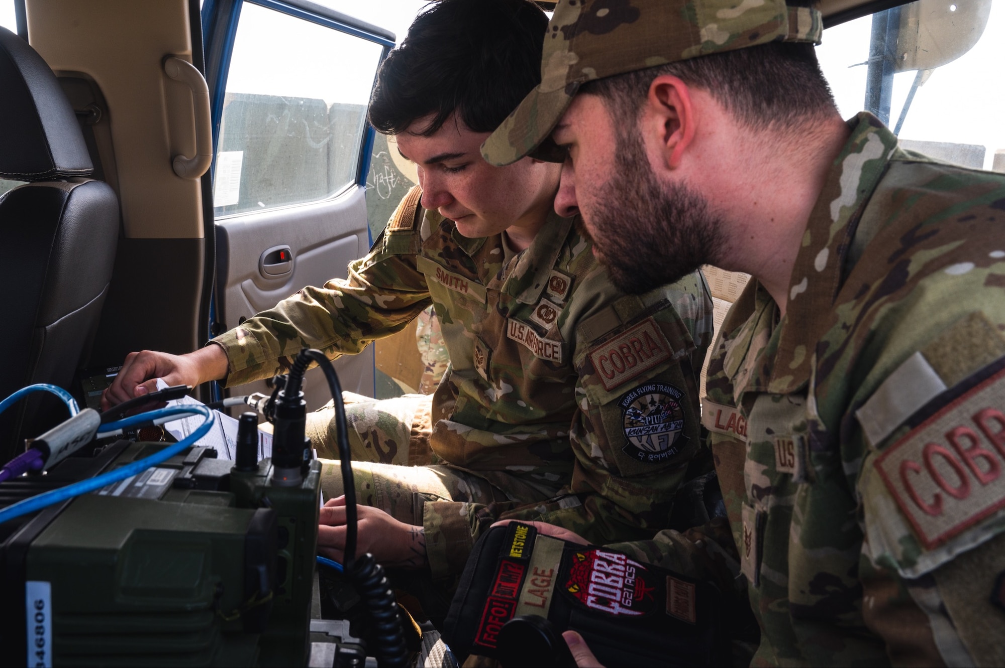 Senior Airman Jordan Smith (left) and U.S. Air Force Staff Sgt. Christopher Lage (right) establish connections for an on-the-go command and control station.