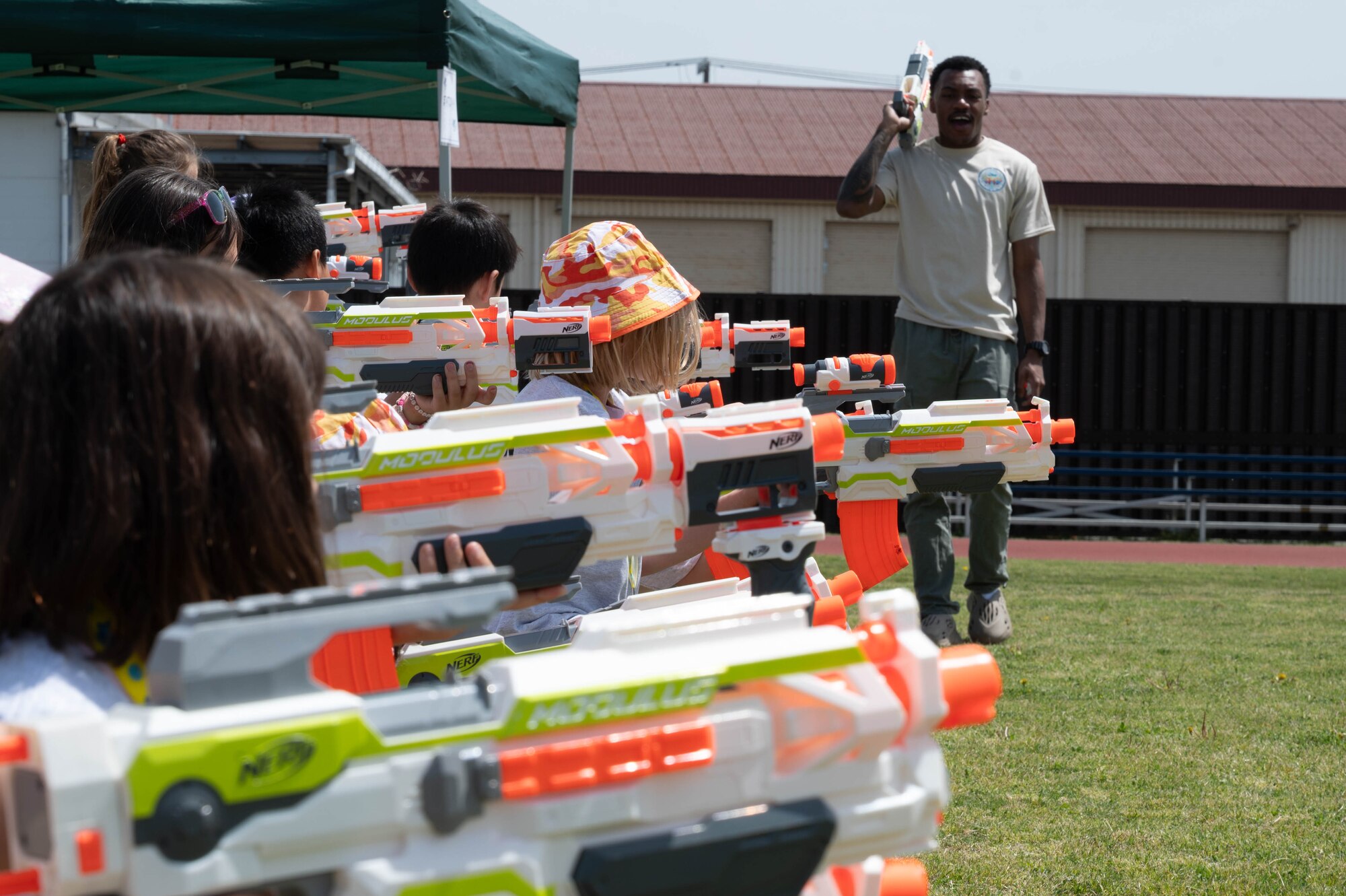 A volunteer instructs children on when to fire their toy weaponry.