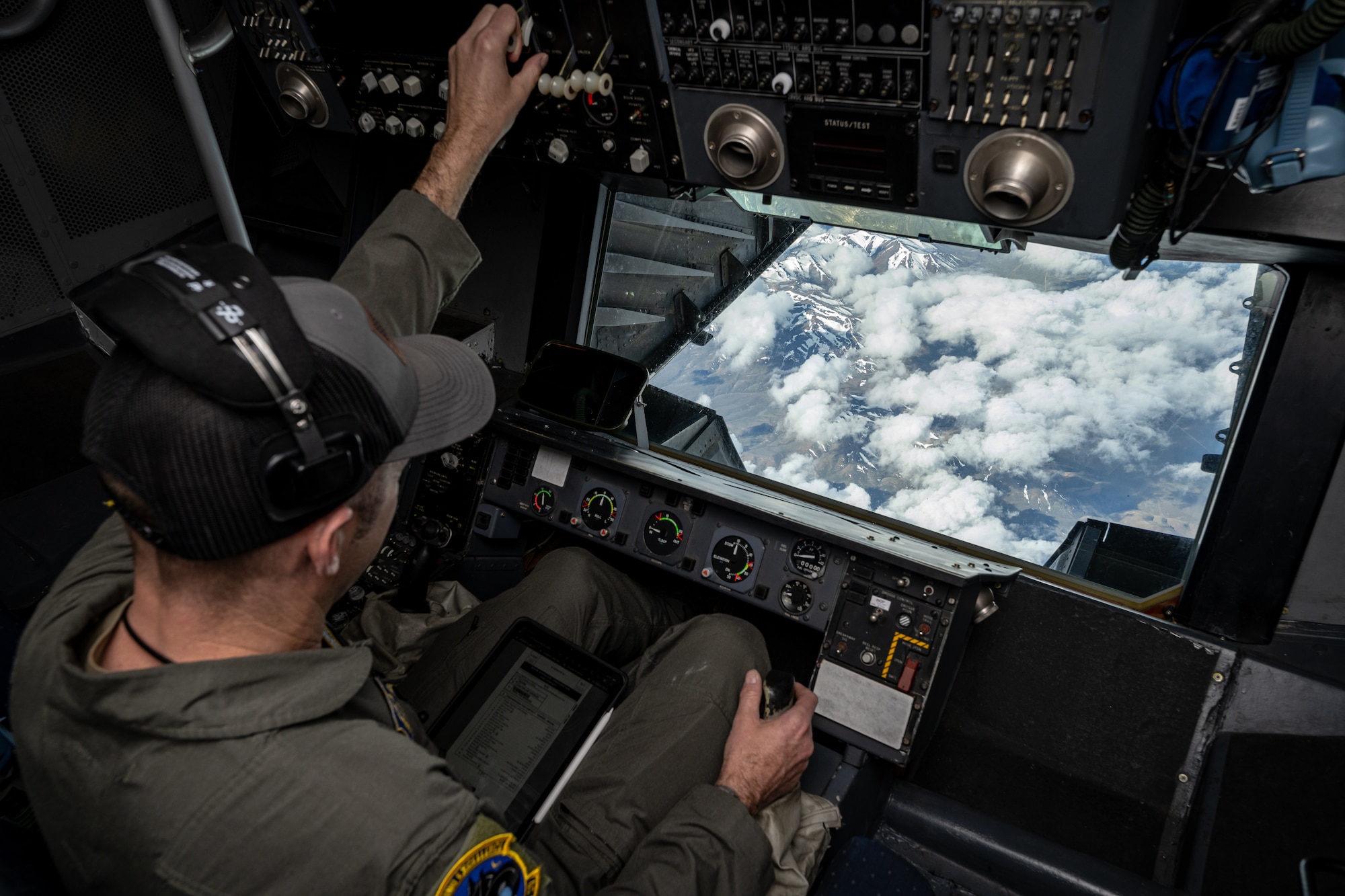 Over the shoulder of Master Sgt. Fortier looking at the snowy Sierra Nevada mountain range through the boom pod window