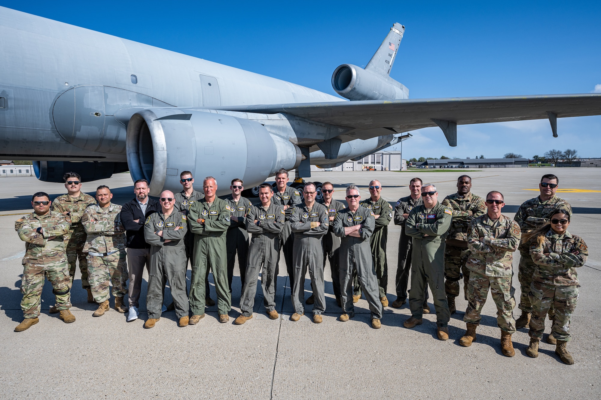 A group photo of the air crew in front of the KC-10 engine and tail
