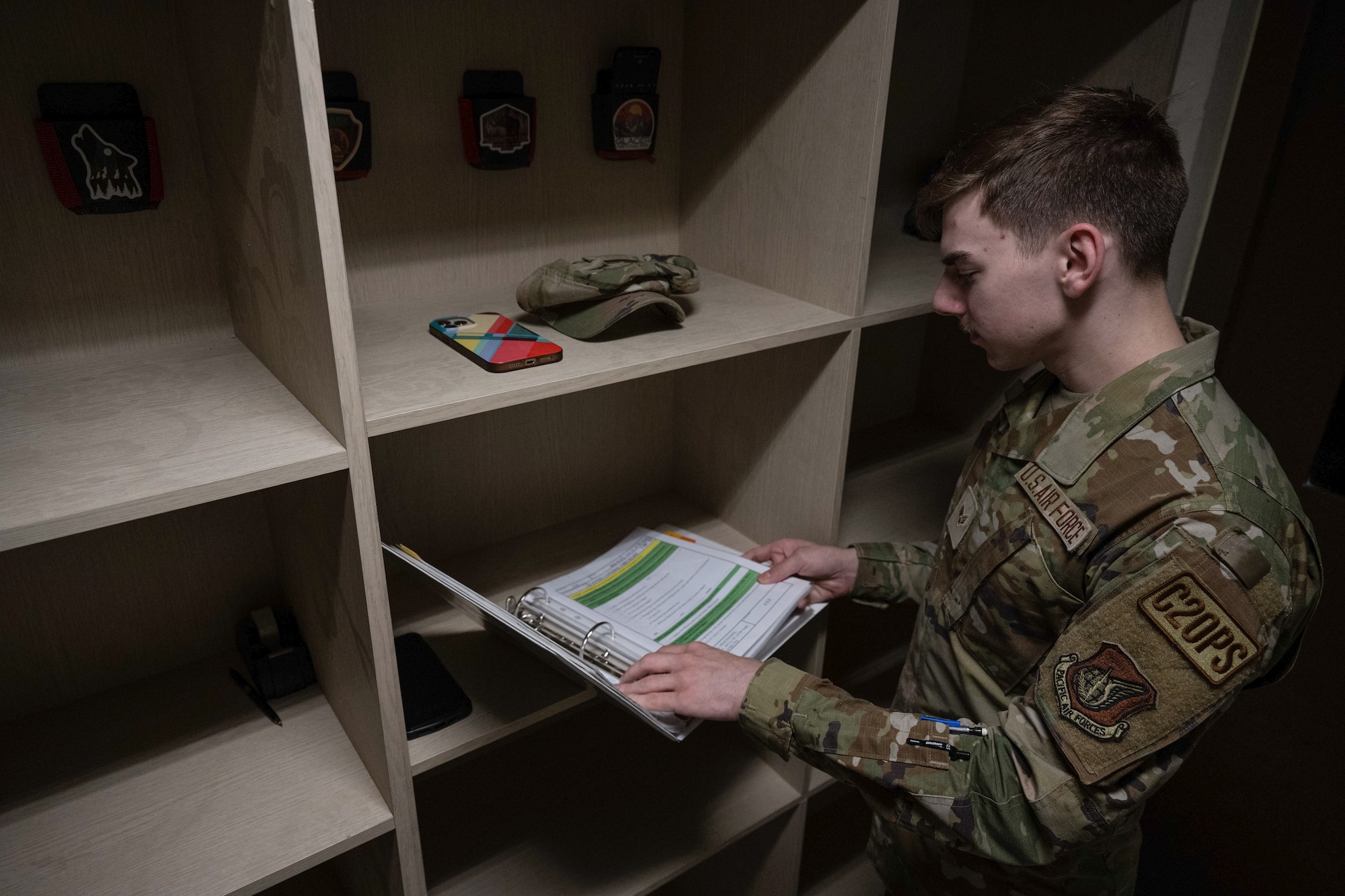 Senior Airman Jaithon Jackson, 8th Fighter Wing emergency actions controller, reviews the check-in binder for the command post at Kunsan Air Base