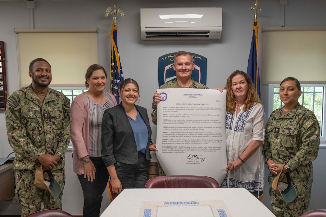Capt. Odin J. Klug, commanding officer, Naval Support Activity Souda Bay, signs a Sexual Assault Awareness and Prevention Month proclamation with Fleet and Family Service Center employees and Sailors assigned to NSA Souda Bay who serve as command sexual assault victim advocates onboard NSA Souda Bay on April 24, 2024.