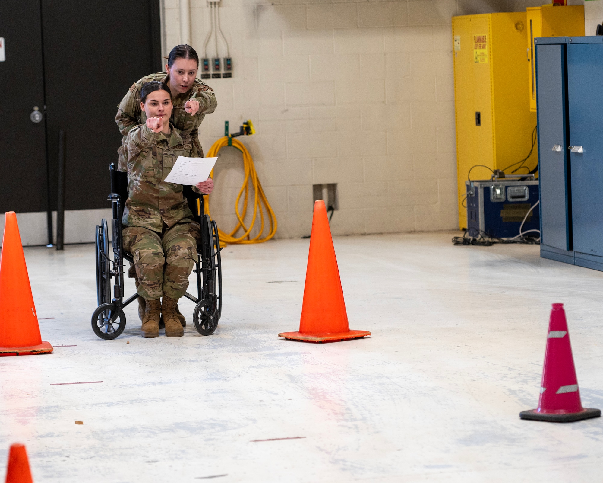 U.S. Air Force Senior Airman Kaitlyn Stahn and Airman Emmah Wittwer, 133rd Air Transportation Function, plan the route for the blindfolded wheelchair station in St. Paul, Minn., April 5, 2024.