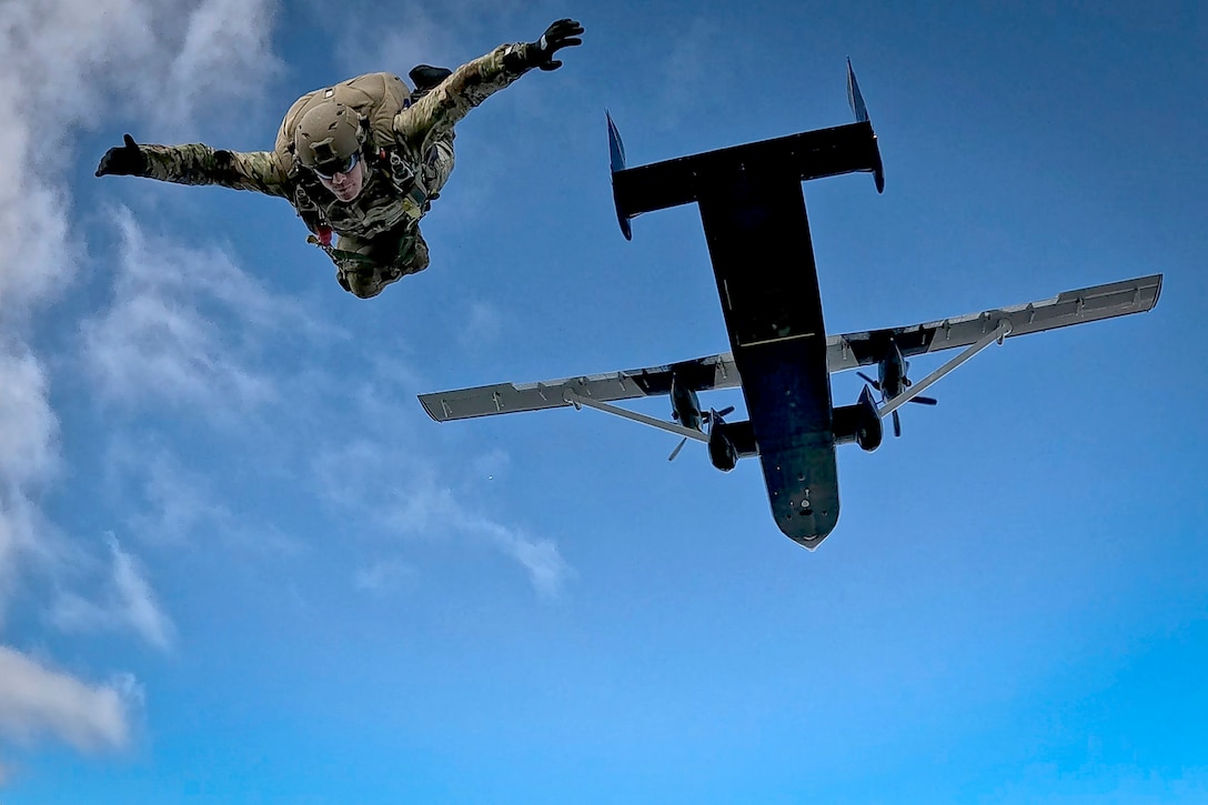 A sailor looks downwards after parachuting from an aircraft.