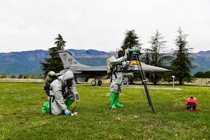 Two Airman in hazmat suits take readings
