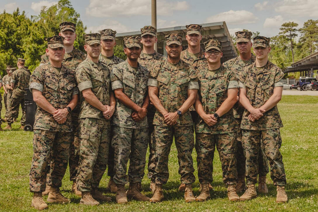 U.S. Marine Corps Col. Damon Burrows, bottom left, the commanding officer of Headquarters Battalion (HQ Bn), 2d Marine Division (MARDIV), and Maj. Gen. Calvert Worth Jr., center, the commanding general of 2d MARDIV, pose for a group photo with Marines from HQ Bn, 2d MARDIV after a formation on Camp Lejeune, North Carolina, April 12, 2024. Worth held a formation to present challenge coins to Marines who embody the values of 2d MARDIV and consistently demonstrate the highest standard of leadership and professionalism. (U.S. Marine Corps photo by Lance Cpl. Allegra Catalan-Dyson)