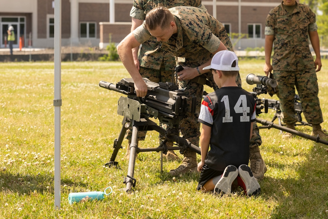U.S. Marine Corps Ethan Jara, a small arms technician with Headquarters and Service Battalion, 2nd Marine Logistics Group, demonstrates how to reload a MK-19 Grenade Launcher during Devil Pup Day on Camp Lejeune, North Carolina, April 19, 2024. H&S Battalion hosted the Devil Pup Day to boost morale, encourage family bonding, and strengthen unit cohesion. (U.S. Marine Corps photo by Lance Cpl. Jessica J. Mazzamuto)