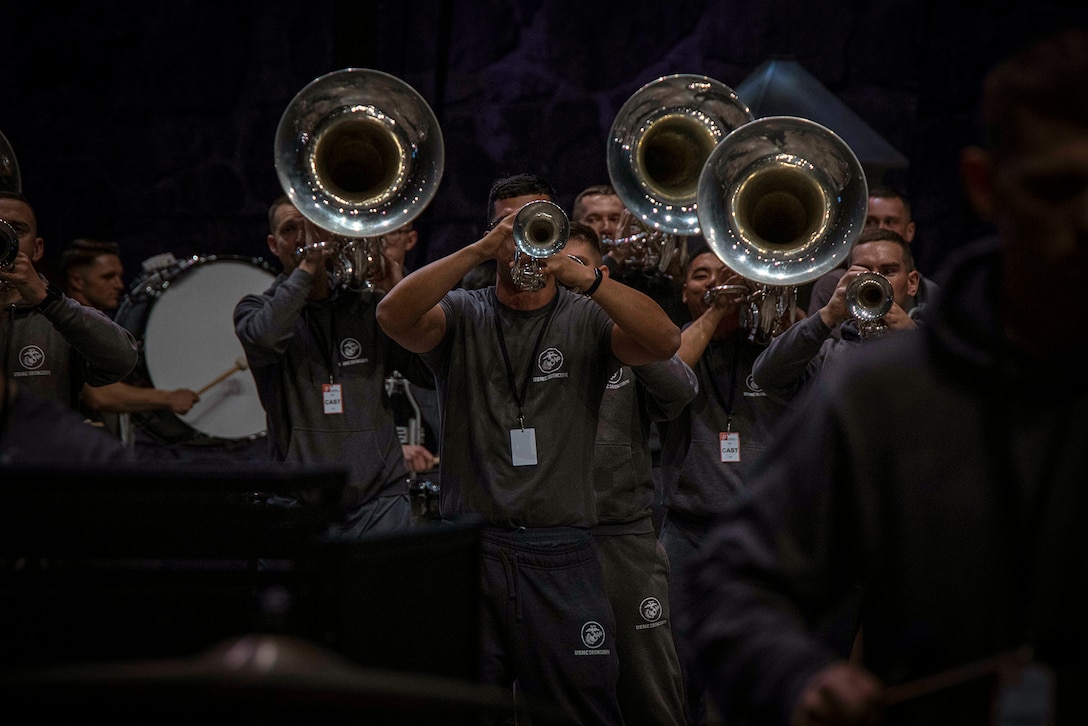 Military musicians rehearse with horns, trumpets and drums for a performance.