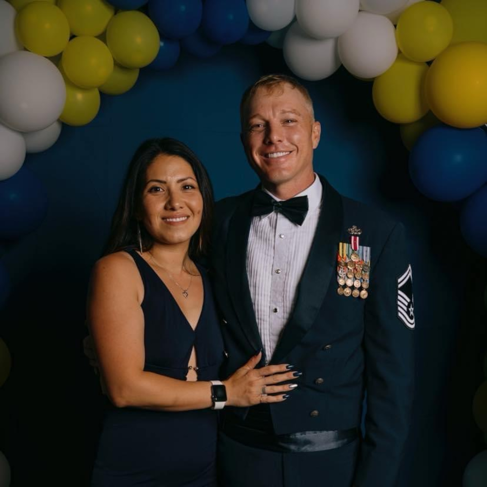 A couple in military service dress smiles for a photo