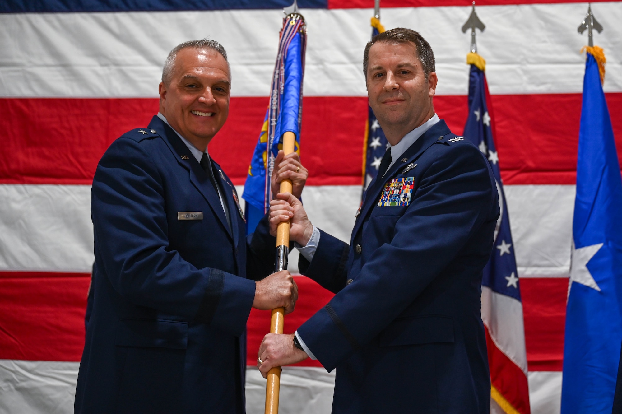 U.S. Air Force Col. Kent Kazmaier passes the guidon to Brig. Gen. David Johnson during a change of command ceremony on Springfield-Beckley Air National Guard Base, Ohio, April 7, 2024. Kazmaier was the commander of the 178th Wing for over a year. (U.S. Air National Guard photo by Airman 1st Class Josh Kaeser)