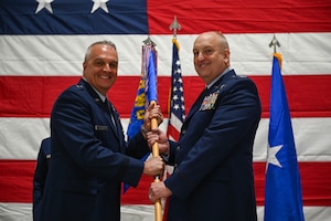 U.S. Air Force Brig. Gen. David Johnson passes the guidon to Col. Donald Braskett during a change of command ceremony on Springfield-Beckley Air National Guard Base, Ohio, April 7, 2024. As the commander, he executes the remotely piloted aircraft MQ-9 Reaper mission. (U.S. Air National Guard photo by Airman 1st Class Josh Kaeser)