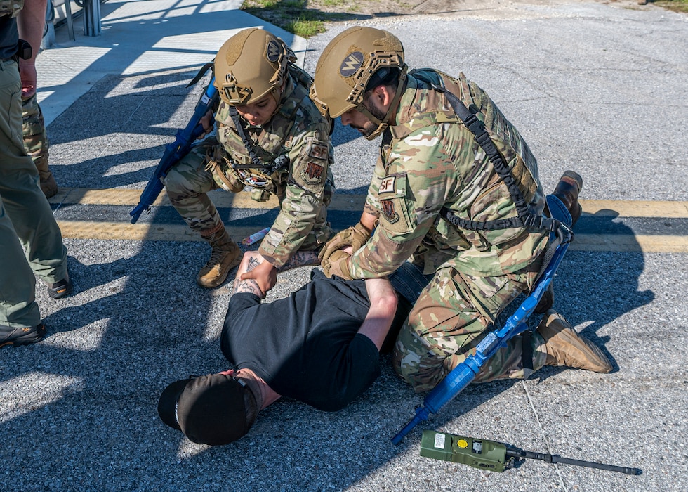 U.S. Air Force Airmen assigned to the 23rd Security Forces Squadron detain an Airman assigned to the 23rd Wing inspection team during Exercise Ready Tiger 24-1 at Avon Park Air Force Range, Florida, April 11, 2024. Building upon previously simulated protest, the inspectors implemented a more violent approach and tried to breach the base perimeter to test security force’s response. Built upon Air Combat Command's directive to assert air power in contested environments, Exercise Ready Tiger 24-1 aims to test and enhance the 23rd Wing’s proficiency in executing Lead Wing and Expeditionary Air Base concepts through Agile Combat Employment and command and control operations. (U.S. Air Force photo by Airman 1st Class Leonid Soubbotine)
