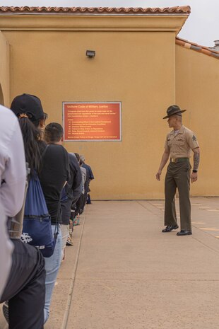 U.S. Marine Corps Sgt. Bryan Ong, a drill instructor with Support Battalion, Recruit Training Regiment, reads the Uniform Code of Military Justice to educators from Recruiting Stations Chicago, Kansas City and Saint Louis on the yellow footprints during the 2024 Educator’s Workshop at Marine Corps Recruit Depot San Diego, California, April 23, 2024. Participants of the workshop visit MCRD San Diego to observe recruit training and gain a better understanding about the transformation from recruits to United States Marines. Educators also received classes and briefs on the benefits that are provided to service members serving in the United States armed forces. (U.S. Marine Corps photo by Lance Cpl. Alexandra M. Earl)