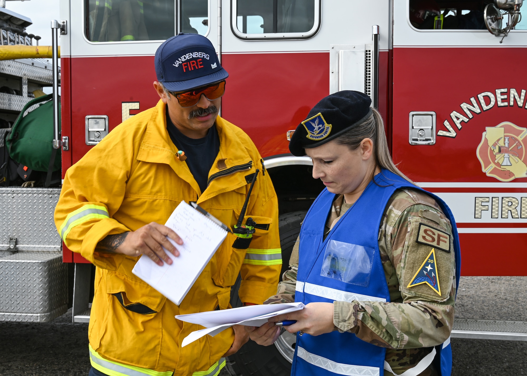 A 30th Civil Engineer Squadron Fire captain explains his response to the Spacecraft Accident Emergency Management Evaluation to a 30th Security Forces Squadron Standardization and Evaluations chief and Delta Inspection Team member at Vandenberg Space Force Base.
