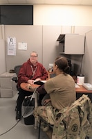 A Department of the Army Civilian employee checks a Soldier's blood pressure