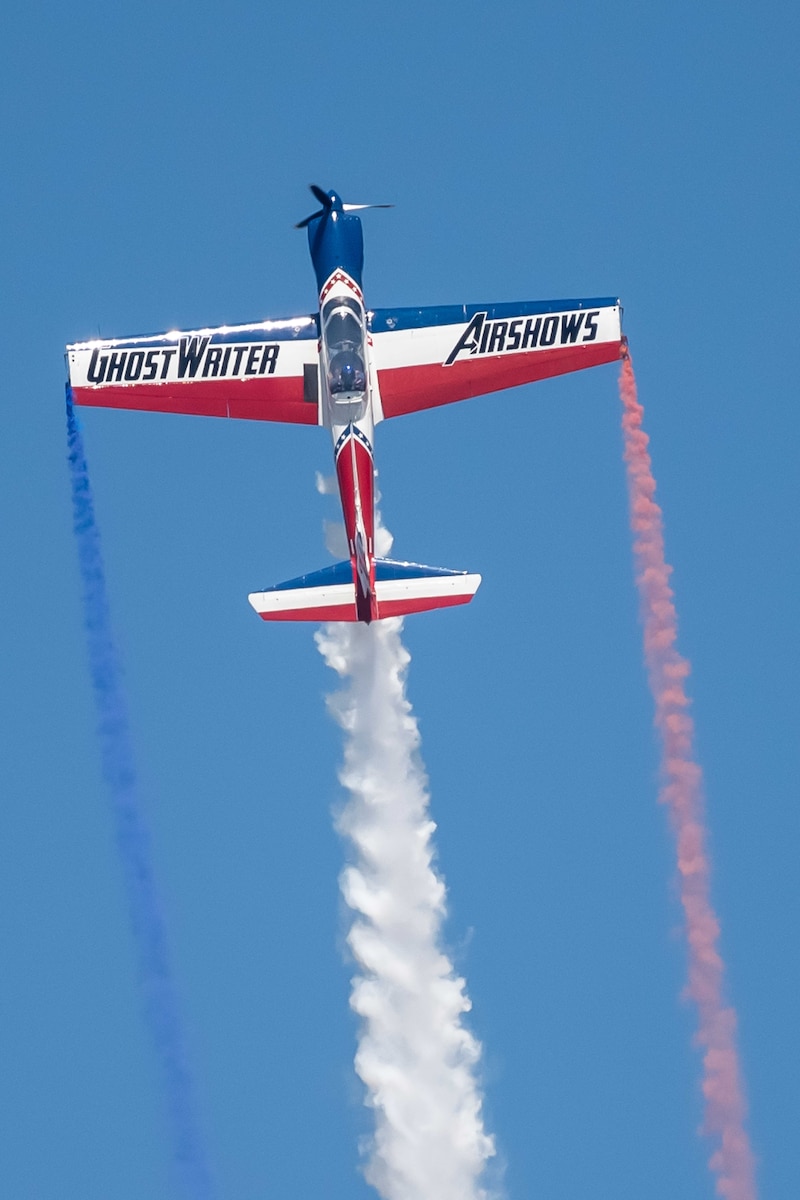 Plane with red, white, and blue smoke