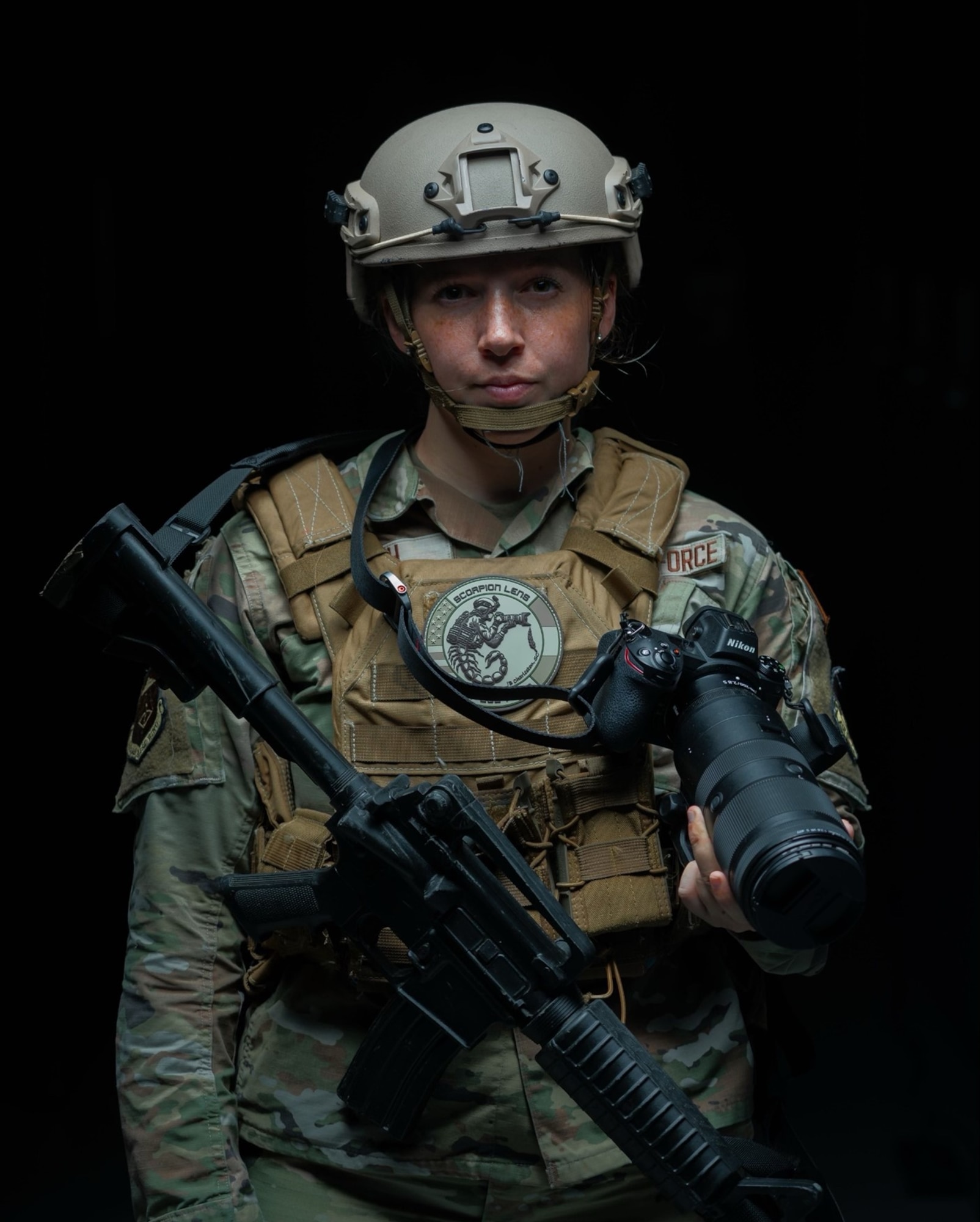 U.S. Air Force photographer holds her camera posing for a portrait