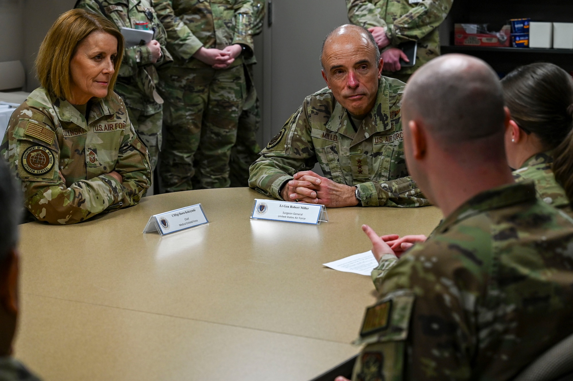 Air Force personnel talk at a table.