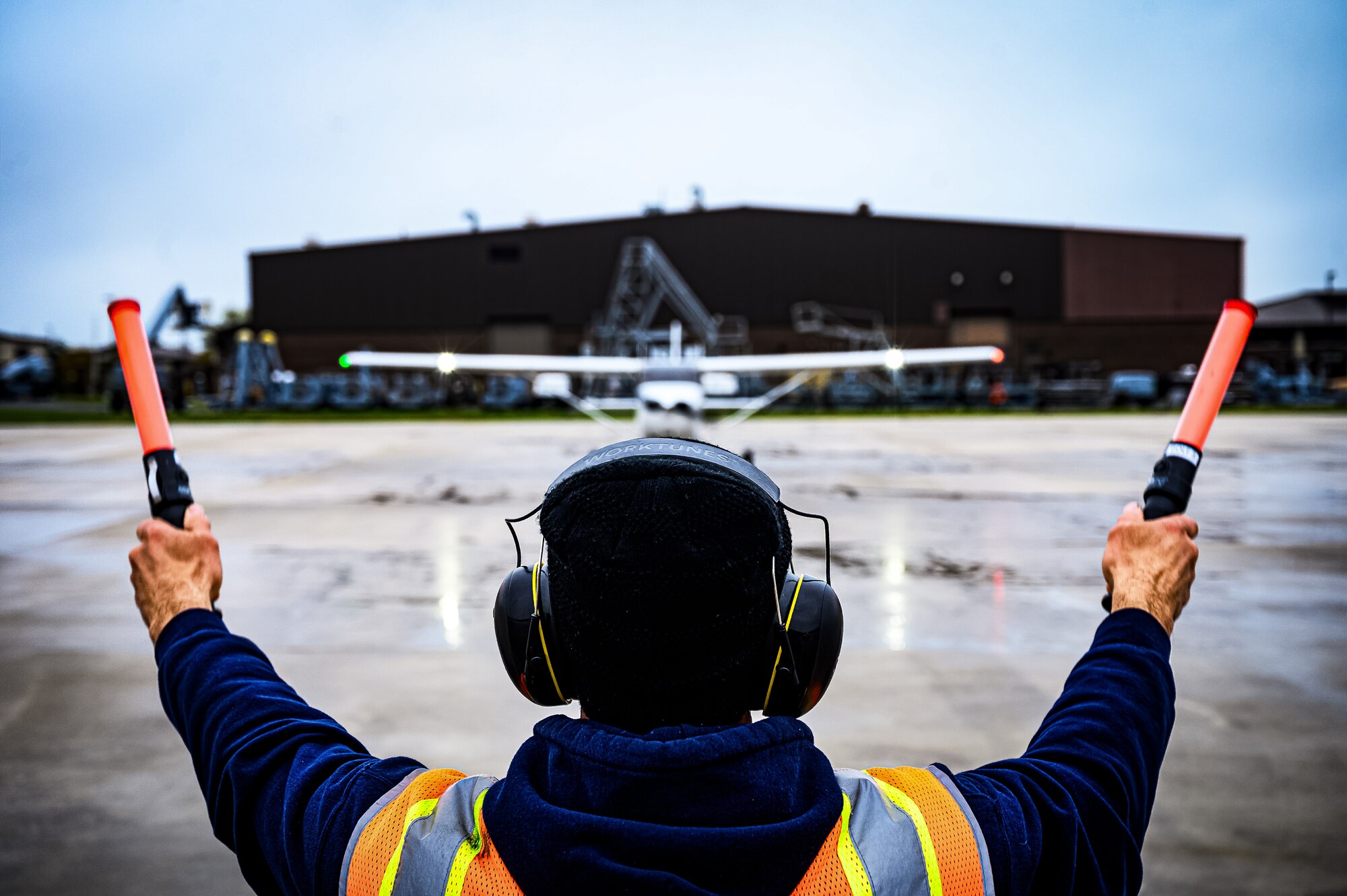 A flight line technician with the 305th Air Mobility Wing signals the arrival of a Cessna 172 at Joint Base McGuire-Dix-Lakehurst, N.J., April 20, 2024. The Mid-Air Collision Avoidance program is designed to ensure safety practices are observed between military and civilian pilots who share a common airspace. (U.S. Air Force photo by Senior Airman Matt Porter)