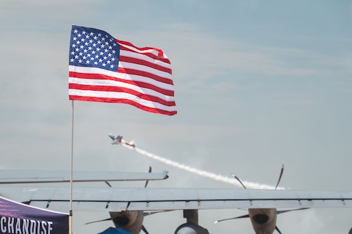 Plane taking off behind a flag