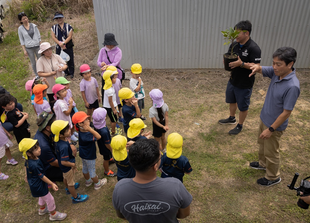 U.S. service members, local preschoolers, and Okinawa residents learn how to plant a mangrove tree during an Earth Day cleanup and tree-planting event at Nature Mirai Kan in Kin Town, Okinawa, Japan, April 22, 2024. Marine Corps Installations Pacific coordinated a week of Earth Day events to reinforce relationships between U.S. service members and the Okinawa community. The participants planted a total of 32 mangrove trees. (U.S. Marine Corps photo by Sgt. Maximiliano Rosas)