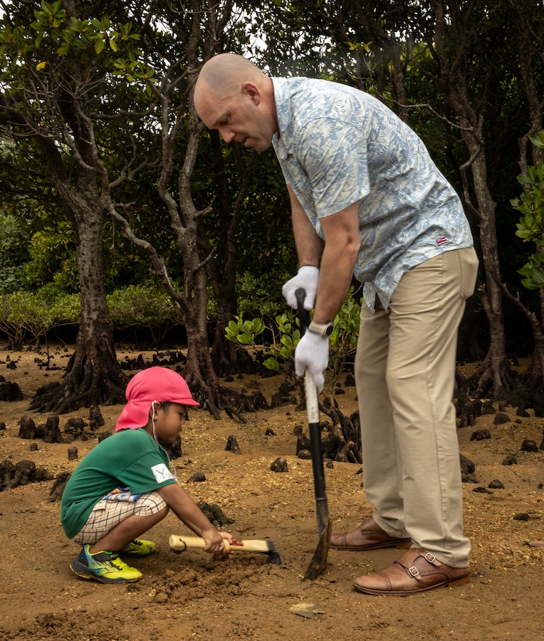 U.S. Marine Corps Col. Richard Martin, commanding officer of Camp Hansen, and a local preschooler plant a Mangrove tree during a park cleanup and tree-planting event at Nature Mirai Kan in Kin Town, Okinawa, Japan, April 22, 2024. Marine Corps Installations Pacific coordinated a week of Earth Day events to reinforce relationships between U.S. service members and the Okinawa community. The participants planted a total of 32 mangrove trees. Martin is a native of Tennessee. (U.S. Marine Corps photo by Sgt. Maximiliano Rosas)