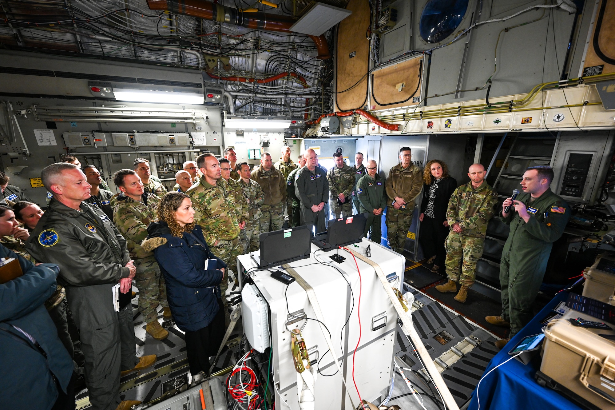 Maj. Christian Brechbuhl, far right, Air Mobility Command mission systems deputy director, briefs senior leaders about the Airlift Tanker Open Mission Systems program on a C-17 Globemaster III April 24, 2024, on the flightline at Ramstein Air Base, Germany.