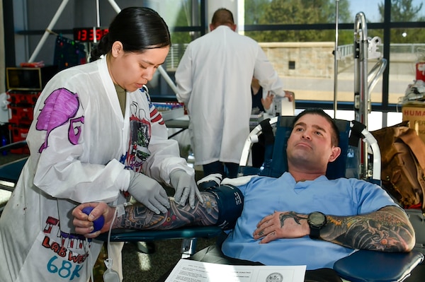 240422-N-QW460-1053 (BREMERTON, WA) U.S. Army Reserve Specialist Leslie Blanco with 7454th Medical Operational Readiness Unit, from San Antonio, Texas, prepares Lt. j.g. Kyle Walker, Kent, Ohio native, with Naval Hospital Bremerton  to donate blood April 22, 2024 during a a blood drive held at NHB in coordination with Madigan Army Medical Center and the Armed Services Blood Program which collected 23 vitally needed unit.(Official Navy Mass Communication 2nd Class Jennifer Benedict, NHB/NMRTC Bremerton public affairs).