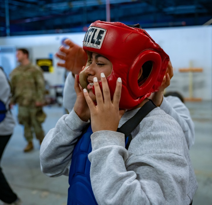 An Air Force Junior ROTC cadet dons a protective helmet before a sparring session at Dover Air Force Base, Delaware, April 24, 2024. The JROTC cadets toured Dover AFB to gain a better understanding of the jobs and duties of the 436th Security Forces Squadron and 436th Force Support Squadron. (U.S. Air Force photo by Airman 1st Class Amanda Jett)