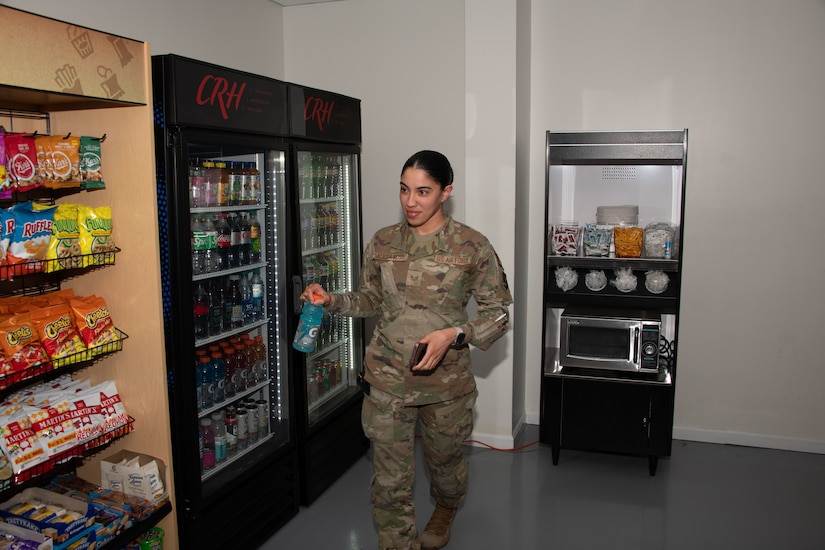 U.S. Air Force Senior Airman Kendra A. Alicea Rosa grabs a drink from the new 24/7 unattended retail unit at Joint Base Andrews, Md., April 25, 2024.