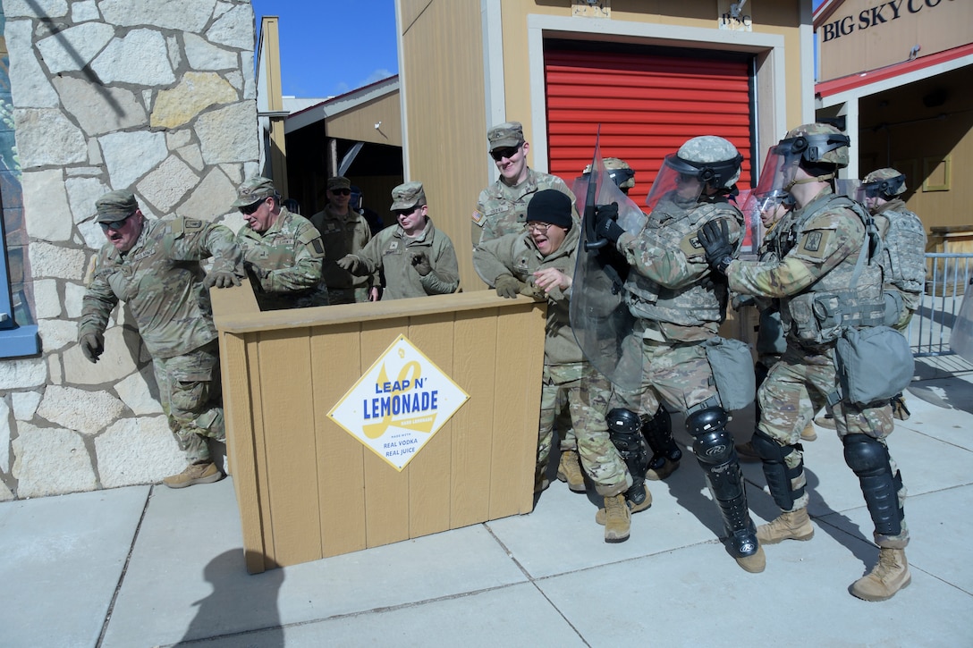 Members of the Wisconsin Army National Guard’s 157th Maneuver Enhancement Brigade role-playing looters escape a notional department store while other Soldiers training in a reaction force role attempt to prevent their escape during an April 5 training exercise with Milwaukee-area law enforcement at the Wisconsin State Fairgrounds in West Allis. Soldiers took turns training in a reaction force role in support of local law enforcement as well as portraying looters and rioters. This type of training addresses communication skills between agencies and improves understanding and collaboration between local law enforcement and the Wisconsin National Guard. Wisconsin Department of Military Affairs photo by Vaughn R. Larson