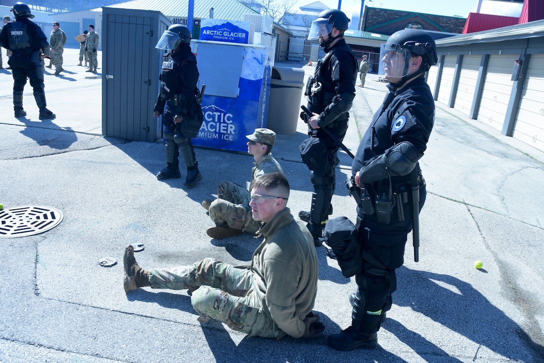 Milwaukee-area law enforcement detain two members of the Wisconsin Army National Guard’s 157th Maneuver Enhancement Brigade role-playing rioters during an April 5 training exercise at the Wisconsin State Fairgrounds in West Allis. Soldiers took turns training in a reaction force role in support of local law enforcement as well as portraying looters and rioters. This type of training addresses communication skills between agencies and improves understanding and collaboration between local law enforcement and the Wisconsin National Guard. Wisconsin Department of Military Affairs photo by Vaughn R. Larson