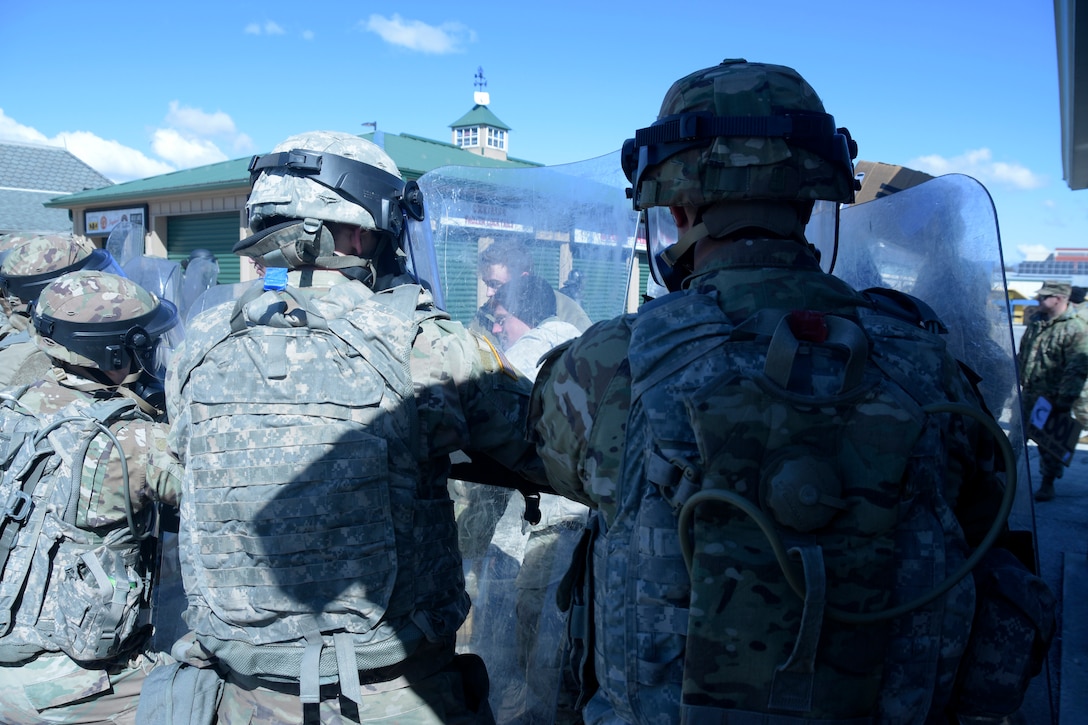 Soldiers with the Wisconsin Army National Guard’s 157th Maneuver Enhancement Brigade attempt to hold the line against notional demonstrators who became violent during an April 5 training exercise with Milwaukee-area law enforcement at the Wisconsin State Fairgrounds in West Allis. Soldiers took turns training in a reaction force role in support of local law enforcement as well as portraying looters and rioters. This type of training addresses communication skills between agencies and improves understanding and collaboration between local law enforcement and the Wisconsin National Guard. Wisconsin Department of Military Affairs photo by Vaughn R. Larson