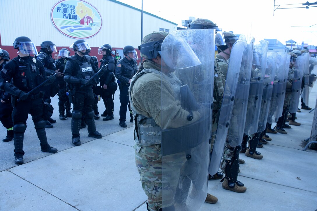 Members of the Wisconsin Army National Guard’s 157th Maneuver Enhancement Brigade took part in a training exercise with Milwaukee-area law enforcement April 5 at the Wisconsin State Fairgrounds in West Allis. Soldiers took turns training in a reaction force role in support of local law enforcement as well as portraying looters and rioters. This type of training addresses communication skills between agencies and improves understanding and collaboration between local law enforcement and the Wisconsin National Guard. Wisconsin Department of Military Affairs photo by Vaughn R. Larson