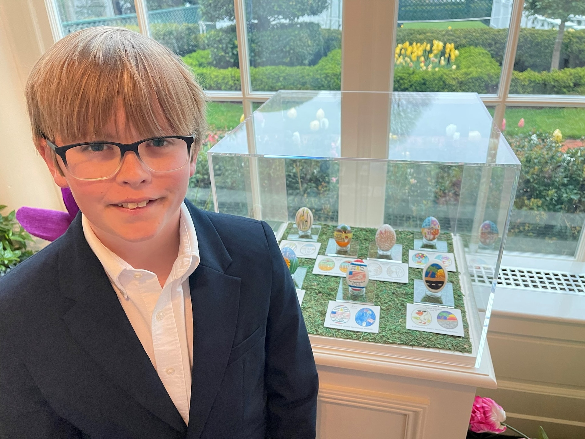 Eli Willingham, son of Sgt. 1st Class Vincent Willingham, readiness Non-commissioned officer for the Headquarters and Headquarters Company, 1792nd Combat Sustainment Support Battalion, poses with the egg he submitted to the White House for First Lady's Egg Roll design contest that was later picked to be displayed in the White House East Colonnade